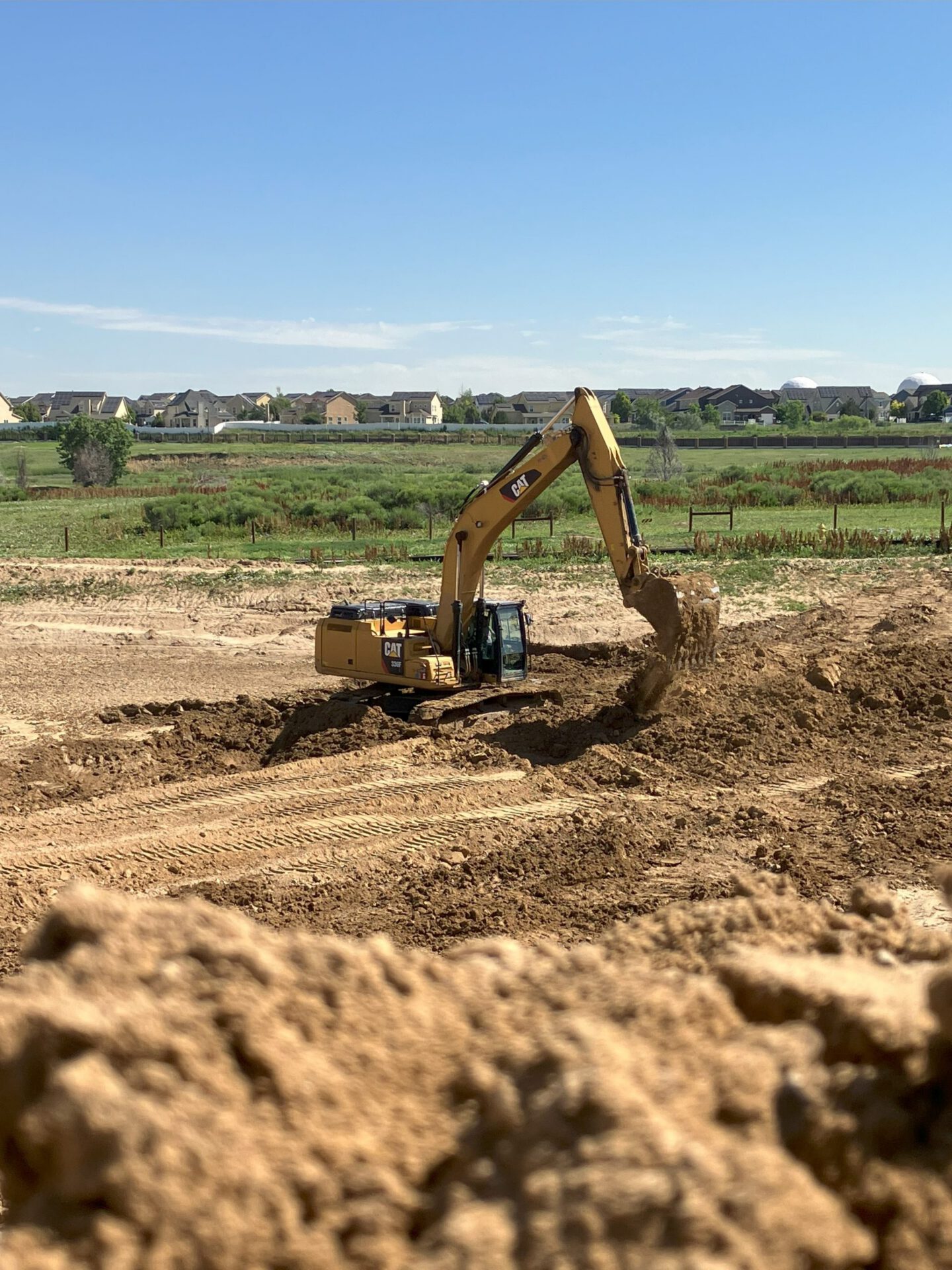 Excavator grading a development site
